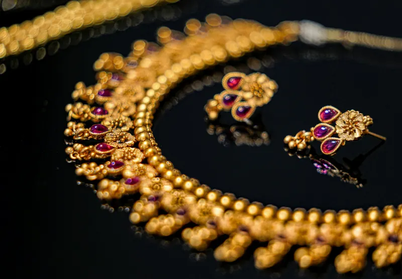 Gold Indian temple jewelry set with ruby-studded jhumka earrings and a matching necklace