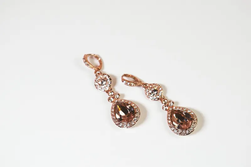 Rose-gold crystal pear drop earrings on white, an elegant drop style in the spirit of Chanel earrings
