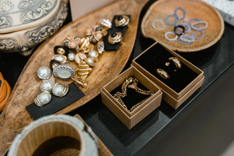 Assorted types of earrings and pearls arranged in small trays and boxes